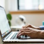 person typing on silver Macbook