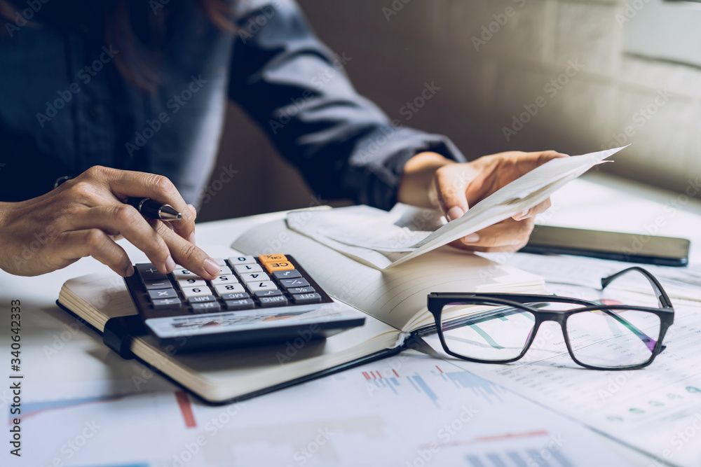 Stressed young woman checking bills, taxes, bank account balance and calculating expenses in the living room at home